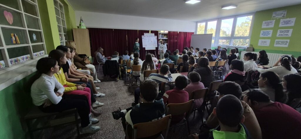 grupa učenika sedi u školskoj biblioteci