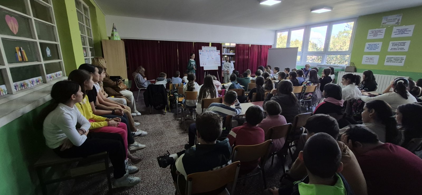 Grupa učenika sedi u školskoj biblioteci